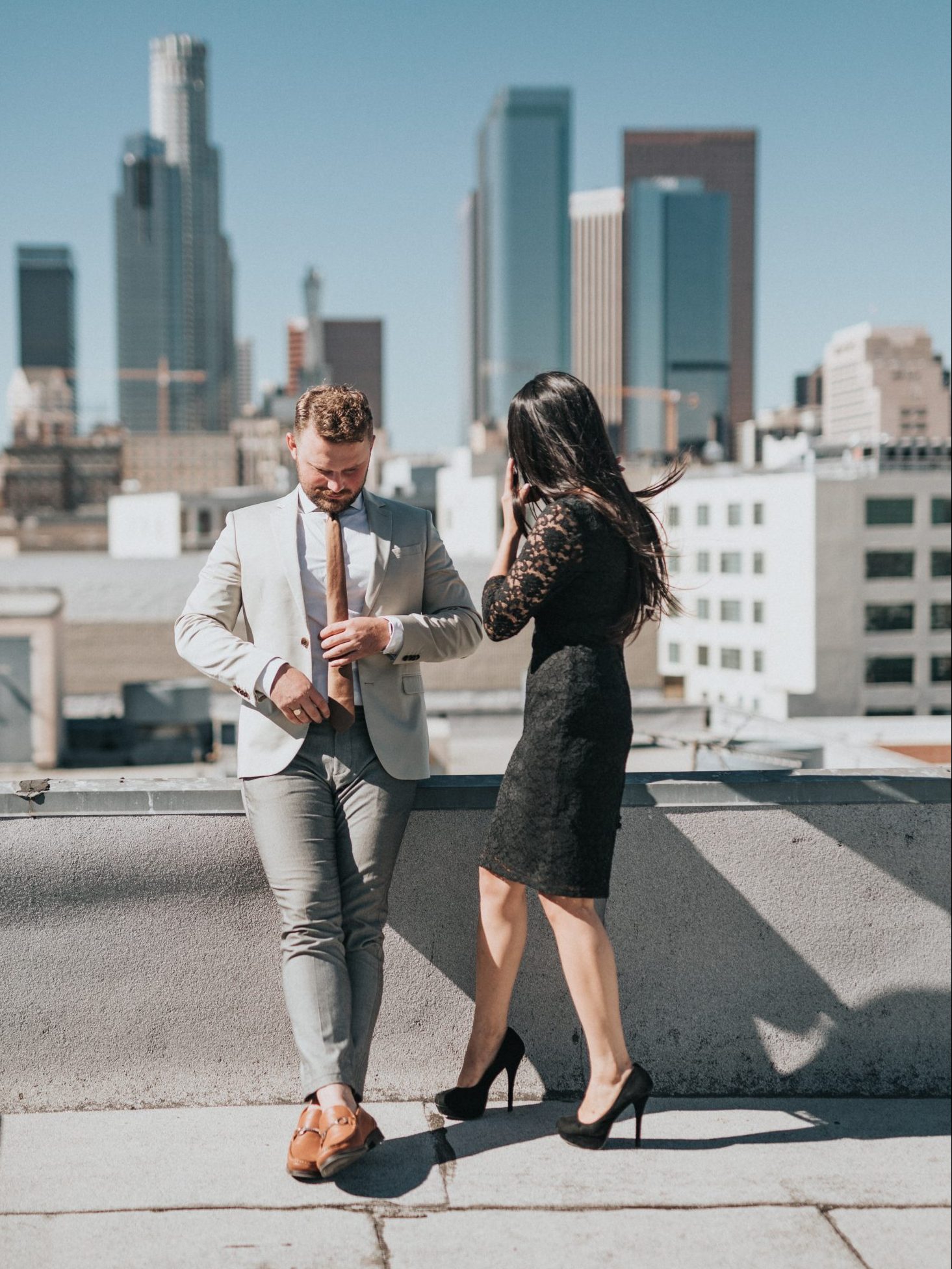 man and woman standing on rooftop of building during daytime